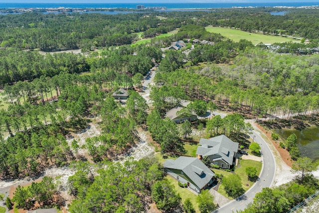 aerial view with a wooded view and a water view