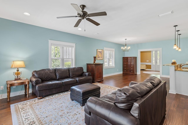 living area featuring dark wood-type flooring, plenty of natural light, recessed lighting, and ceiling fan with notable chandelier