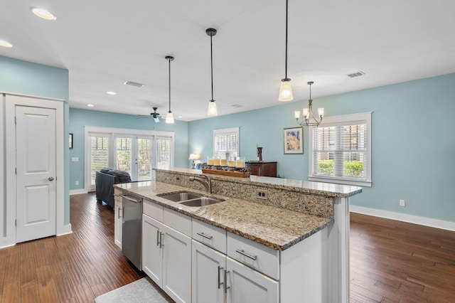 kitchen with a sink, open floor plan, dishwasher, baseboards, and visible vents