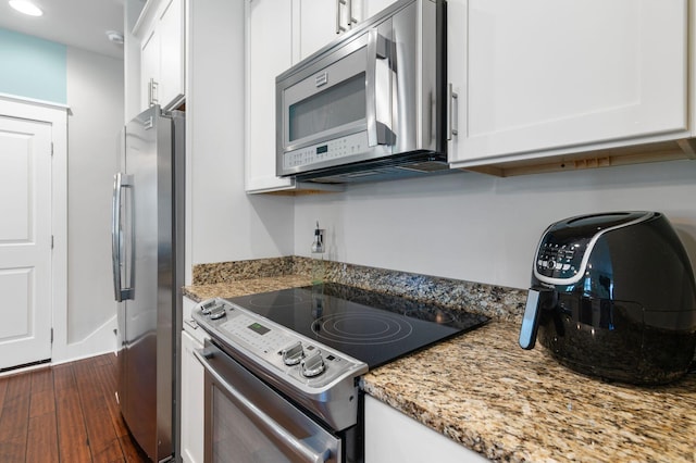 kitchen featuring white cabinetry, appliances with stainless steel finishes, light stone countertops, dark wood-type flooring, and recessed lighting