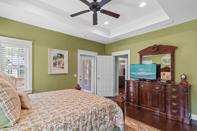 bedroom featuring visible vents, dark wood-style floors, a raised ceiling, and crown molding