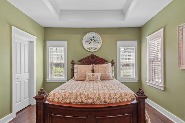 bedroom with dark wood finished floors, ornamental molding, and multiple windows