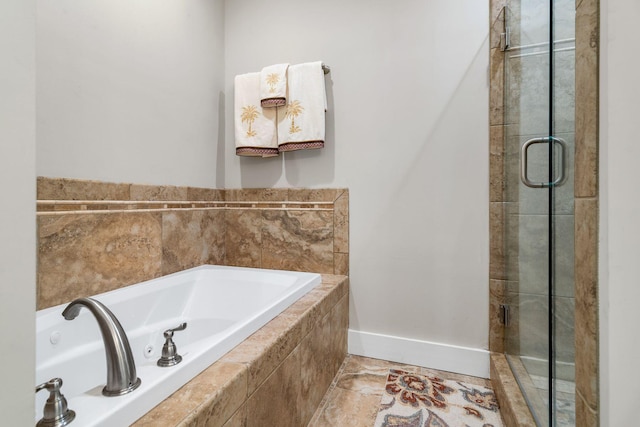 full bathroom with baseboards, a garden tub, and a stall shower