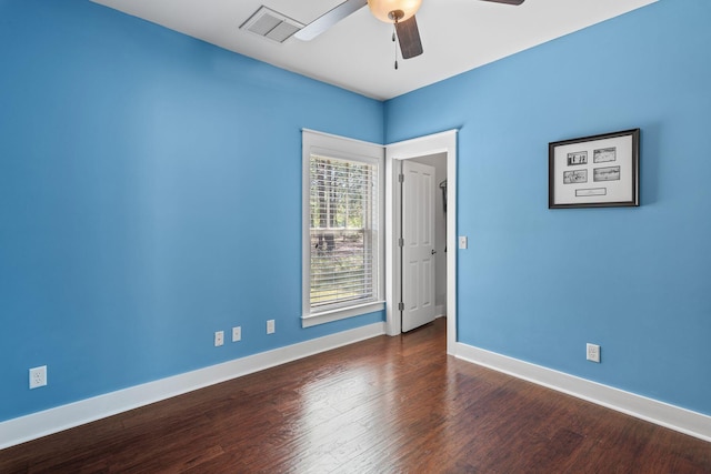spare room with baseboards, wood finished floors, visible vents, and ceiling fan