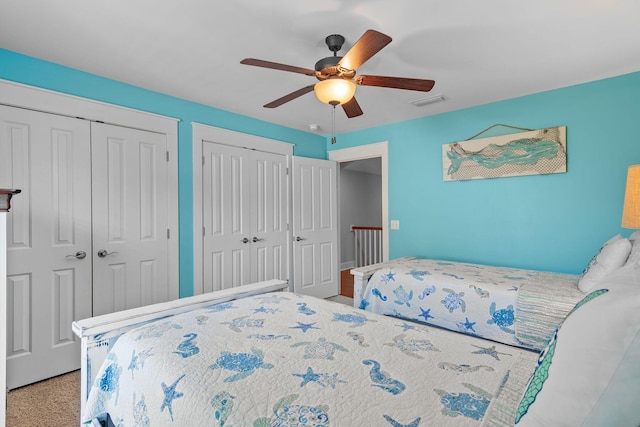 bedroom featuring multiple closets, ceiling fan, and visible vents