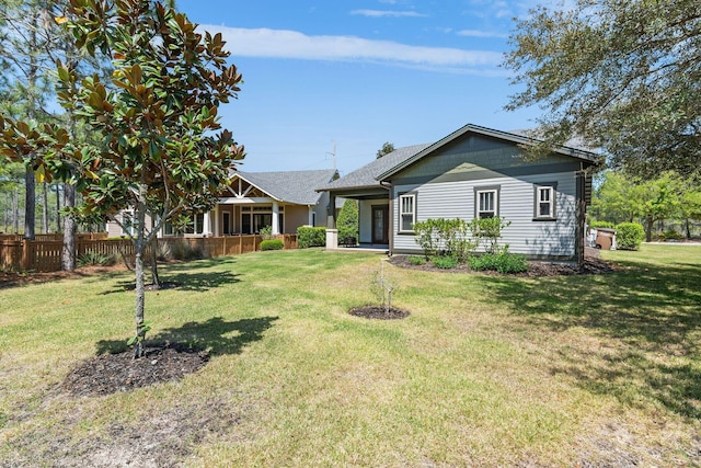 view of front of home with a front yard and fence