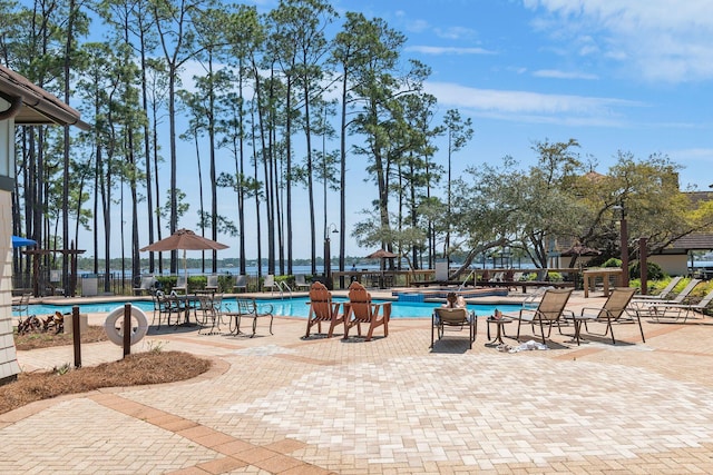 community pool with fence and a patio area