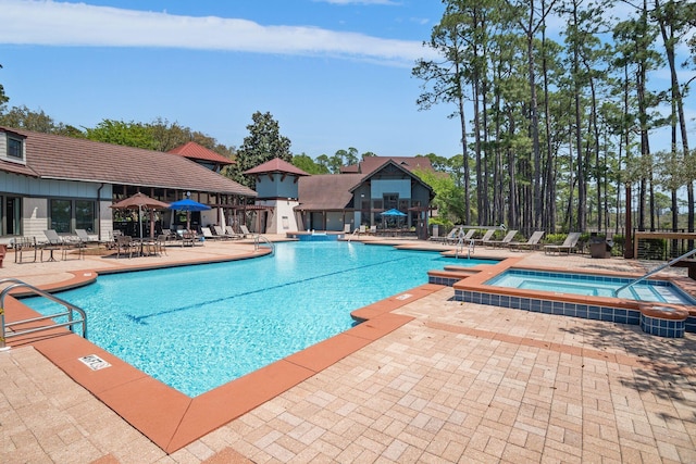 community pool with a community hot tub and a patio area