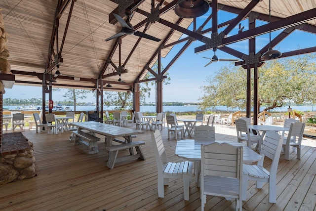 deck featuring outdoor dining space, a water view, and ceiling fan
