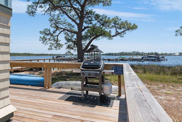 deck with area for grilling and a water view