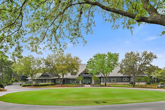 view of community with a lawn and curved driveway