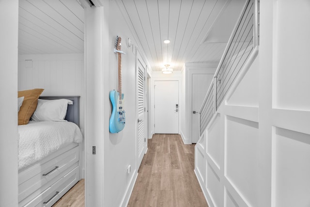 corridor with light wood-style floors, wooden ceiling, and recessed lighting