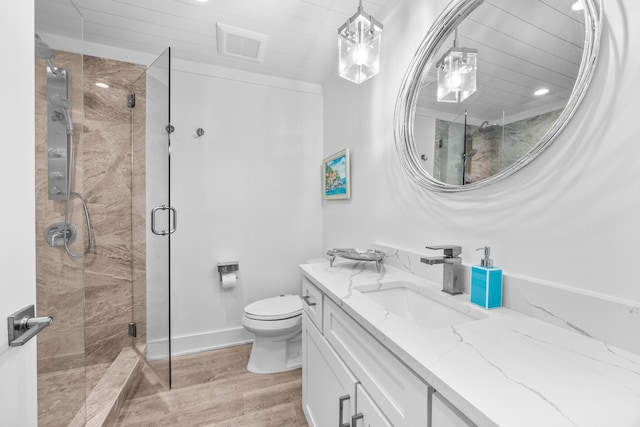bathroom featuring vanity, visible vents, wood finished floors, toilet, and a shower stall