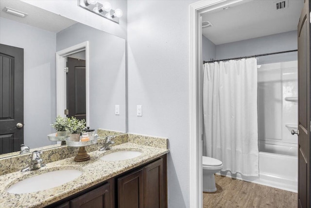 3129 Partridge Dr, Crestview, FL 32539 - full bath featuring wood finished floors, toilet, double vanity, and shower / tub combo with curtain
