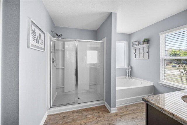 3129 Partridge Dr, Crestview, FL 32539 - bathroom with a stall shower, wood finished floors, baseboards, a garden tub, and vanity