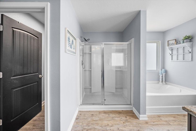 3129 Partridge Dr, Crestview, FL 32539 - full bath featuring a stall shower, wood finished floors, a bath, and baseboards