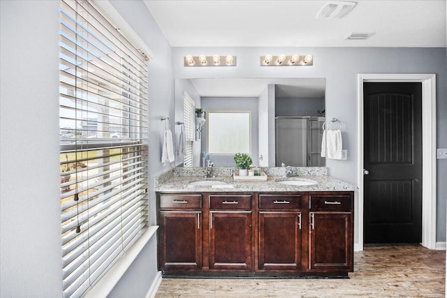 3129 Partridge Dr, Crestview, FL 32539 - full bathroom with a shower stall, wood finished floors, healthy amount of natural light, and double vanity