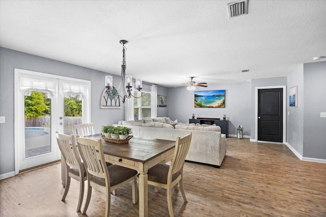 3129 Partridge Dr, Crestview, FL 32539 - dining area with wood finished floors, a textured ceiling, baseboards, ceiling fan, and a chandelier