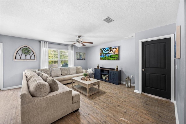 3129 Partridge Dr, Crestview, FL 32539 - living room featuring a ceiling fan, a textured ceiling, wood finished floors, and baseboards