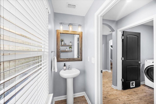 3129 Partridge Dr, Crestview, FL 32539 - bathroom featuring washer / dryer, wood finished floors, baseboards, and a sink