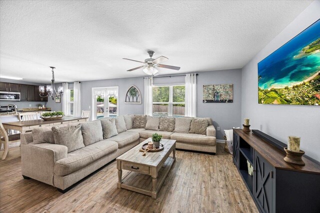 3129 Partridge Dr, Crestview, FL 32539 - living room with a textured ceiling, light wood finished floors, a ceiling fan, and a chandelier