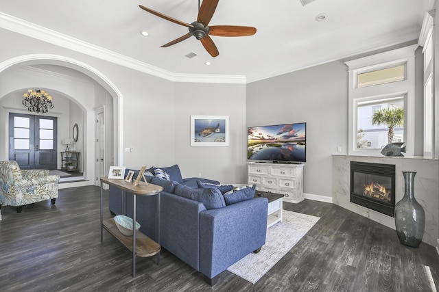 4720 Rendezvous Cv, Destin, FL 32541 - living area featuring dark wood-type flooring, arched walkways, ornamental molding, a tile fireplace, and a ceiling fan
