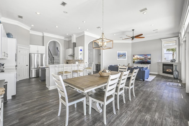 4720 Rendezvous Cv, Destin, FL 32541 - dining area with ceiling fan, recessed lighting, a glass covered fireplace, dark wood-type flooring, and crown molding