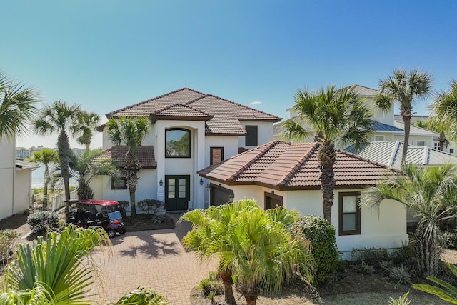 4720 Rendezvous Cv, Destin, FL 32541 - mediterranean / spanish house featuring french doors, stucco siding, an attached garage, a tile roof, and decorative driveway