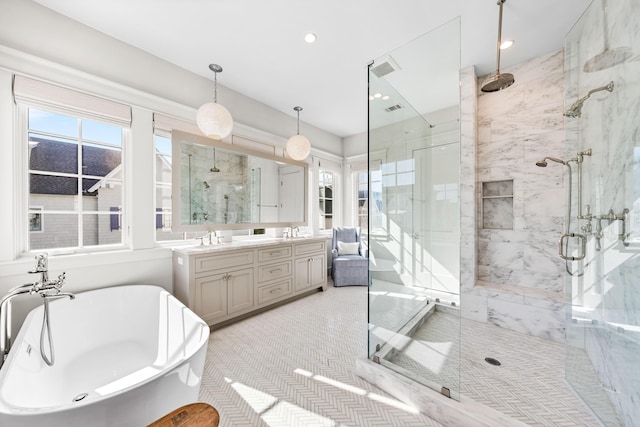 bathroom featuring a marble finish shower, a sink, a freestanding tub, and double vanity