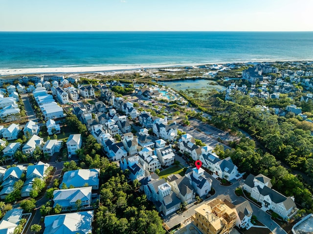 drone / aerial view featuring a view of the beach, a residential view, and a water view