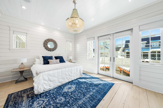 bedroom featuring access to exterior, hardwood / wood-style flooring, and multiple windows