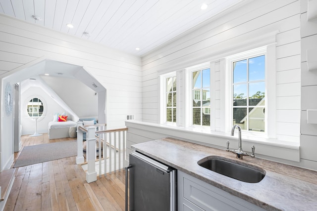 kitchen featuring recessed lighting, a sink, light wood-style floors, light stone counters, and refrigerator