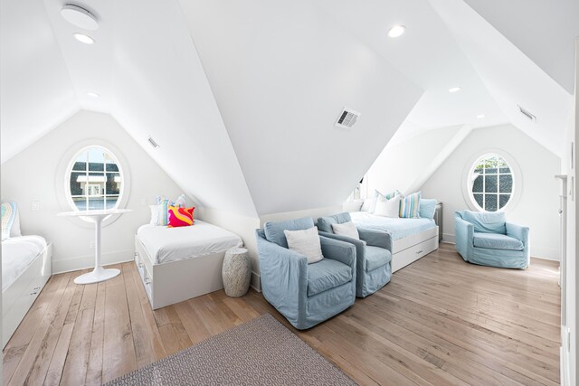 bedroom featuring hardwood / wood-style floors, visible vents, and lofted ceiling
