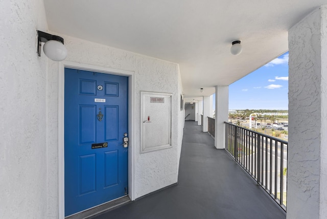 entrance to property with a balcony and stucco siding