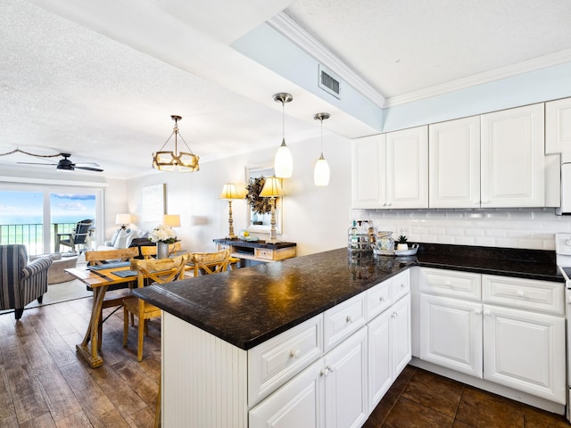 5801 Thomas Dr Unit 415, Panama City Beach, FL 32408 - kitchen with a peninsula, backsplash, white cabinetry, and ornamental molding