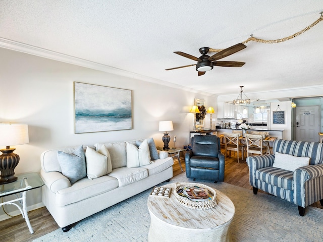 5801 Thomas Dr Unit 415, Panama City Beach, FL 32408 - living area with ceiling fan with notable chandelier, wood finished floors, a textured ceiling, and crown molding
