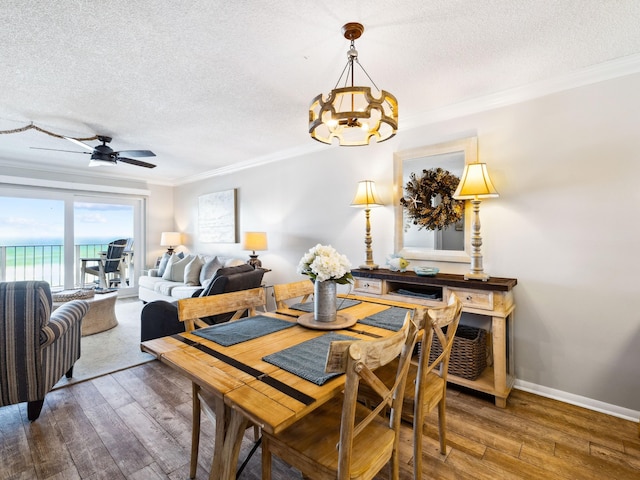5801 Thomas Dr Unit 415, Panama City Beach, FL 32408 - dining area featuring hardwood / wood-style flooring, crown molding, a textured ceiling, and ceiling fan with notable chandelier