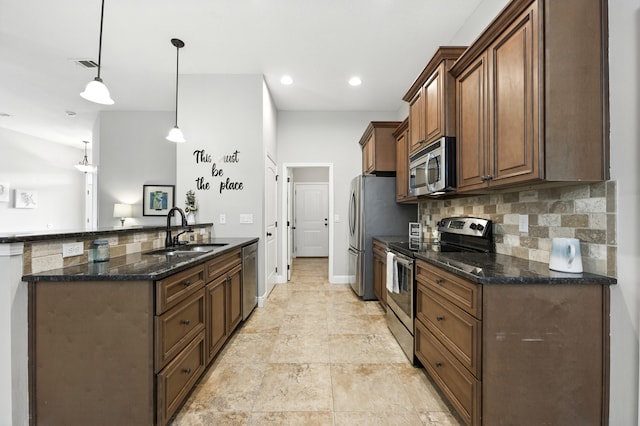472 W College Blvd, Valparaiso, FL 32580 - kitchen with appliances with stainless steel finishes, tasteful backsplash, dark stone countertops, pendant lighting, and brown cabinetry