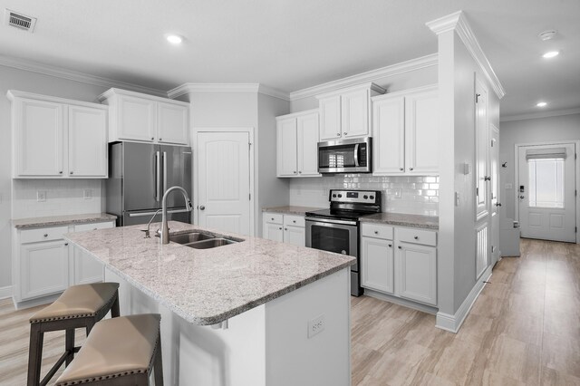 85 Stonegate Dr, Santa Rosa Beach, FL 32459 - kitchen with stainless steel appliances, a sink, a center island with sink, visible vents, and white cabinetry