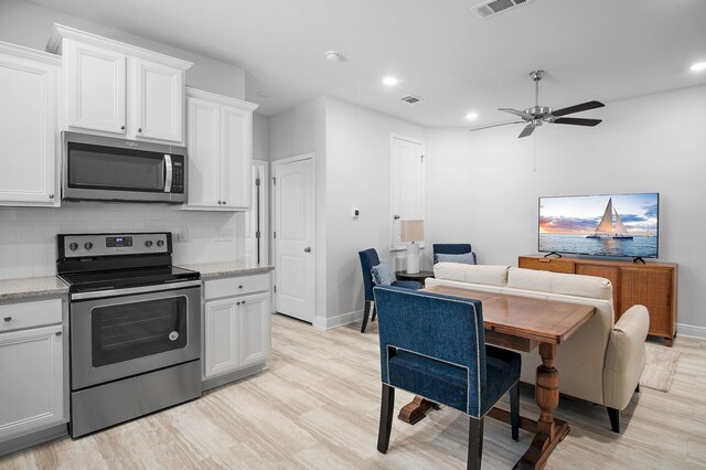 85 Stonegate Dr, Santa Rosa Beach, FL 32459 - kitchen featuring decorative backsplash, baseboards, appliances with stainless steel finishes, and light wood finished floors
