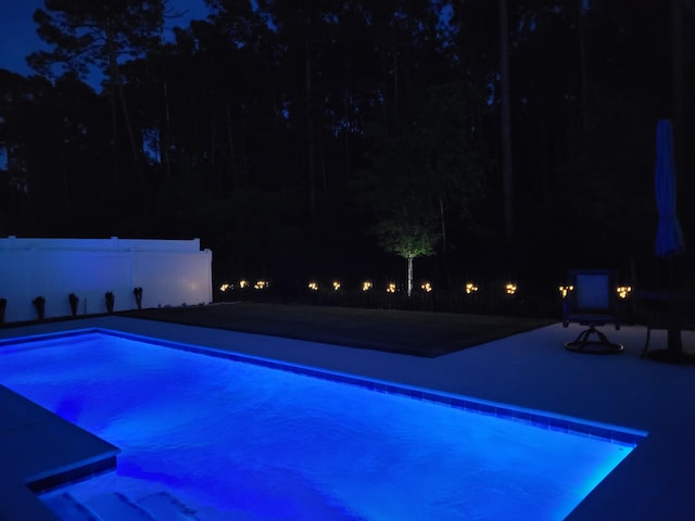 85 Stonegate Dr, Santa Rosa Beach, FL 32459 - pool at twilight featuring a patio area, an outdoor pool, and fence