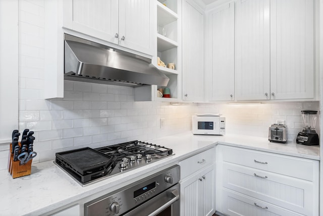 265 Salt Box Ln, Watersound, FL 32461 - kitchen with open shelves, range hood, white cabinets, tasteful backsplash, and appliances with stainless steel finishes