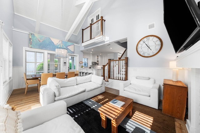 265 Salt Box Ln, Watersound, FL 32461 - living room featuring beam ceiling, high vaulted ceiling, a wainscoted wall, wood finished floors, and visible vents