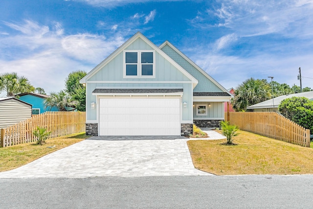 4003 Tarpon St, Panama City Beach, FL 32408 - craftsman inspired home featuring board and batten siding, stone siding, decorative driveway, fence, and a garage