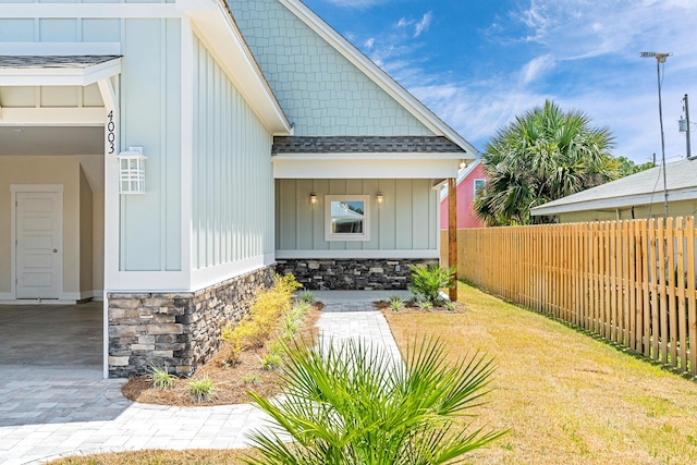 4003 Tarpon St, Panama City Beach, FL 32408 - entrance to property with fence, roof with shingles, board and batten siding, and stone siding