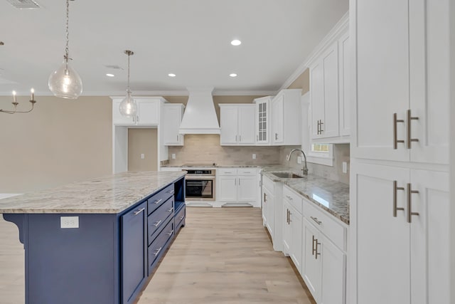 4003 Tarpon St, Panama City Beach, FL 32408 - kitchen featuring a sink, custom range hood, oven, white cabinets, and blue cabinets