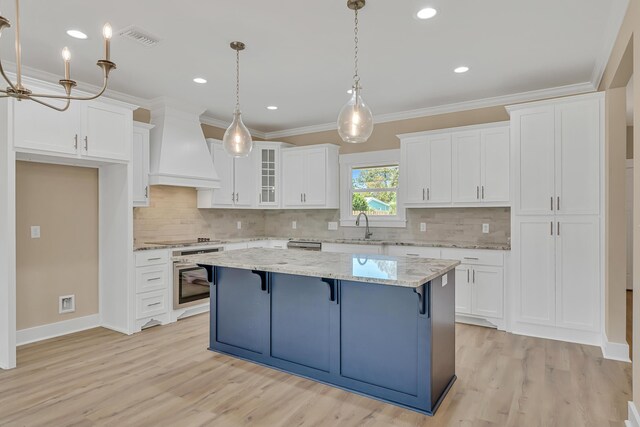 4003 Tarpon St, Panama City Beach, FL 32408 - kitchen with white cabinets, custom range hood, a sink, visible vents, and stainless steel oven