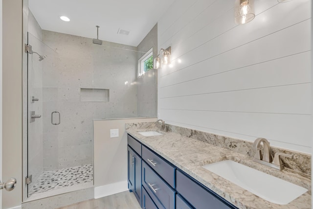 4003 Tarpon St, Panama City Beach, FL 32408 - bathroom with double vanity, wood finished floors, a stall shower, and a sink