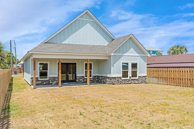 4003 Tarpon St, Panama City Beach, FL 32408 - rear view of property with board and batten siding, roof with shingles, a yard, french doors, and a fenced backyard