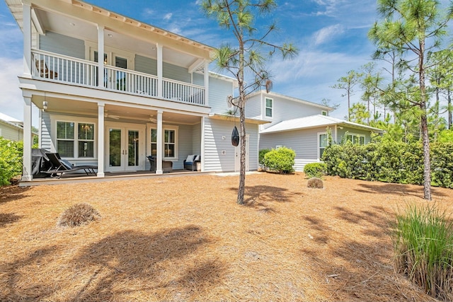 back of property with french doors, ceiling fan, a patio area, and a balcony